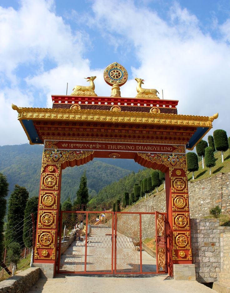 Ornate red and gold temple gate hung with prayer flags